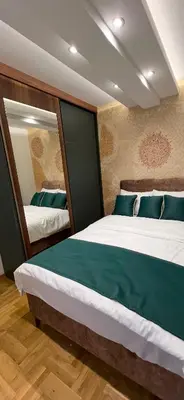 a bedroom with two beds with green pillows at Apartman Lux Jocić in Vrnjačka Banja
