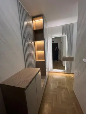 a room with a hallway with a wooden floor and a table at Apartman Lux Jocić in Vrnjačka Banja