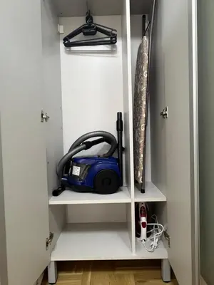 a white cabinet with a vacuum in it at Apartman Lux Jocić in Vrnjačka Banja