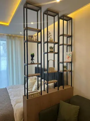 a book shelf in a room with a bed at Apartman B64 Residence Hill Kopaonik in Kopaonik
