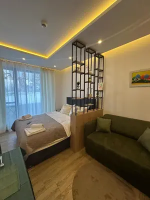 a bedroom with a large bed and a couch at Apartman B64 Residence Hill Kopaonik in Kopaonik