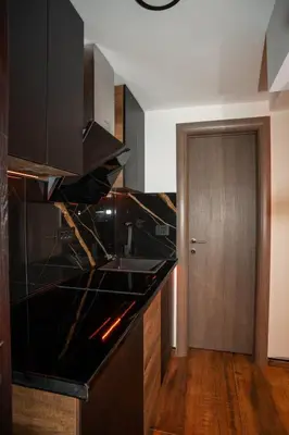a kitchen with a black counter top and a wooden floor at KonKal - Royal resort in Kopaonik