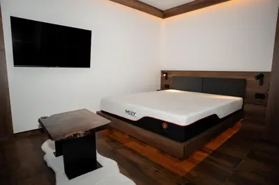 a bedroom with a bed and a flat screen tv at KonKal - Royal resort in Kopaonik