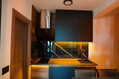 a kitchen with black cabinets and a stove at KonKal - Royal resort in Kopaonik