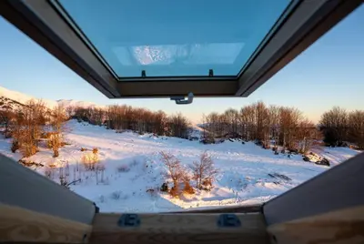 a view of a snow covered field from inside a house at KonKal - Royal resort in Kopaonik