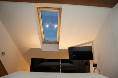 a bedroom with a bed and a tv and a window at KonKal - Royal resort in Kopaonik