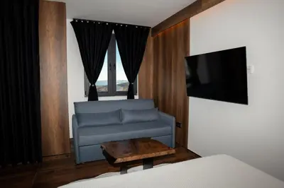 a living room with a couch and a tv at KonKal - Royal resort in Kopaonik