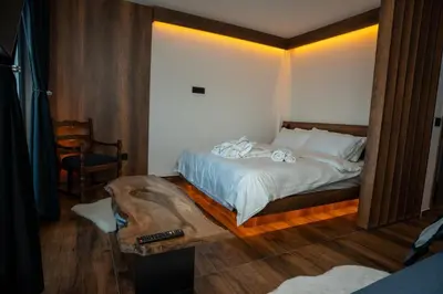 a bedroom with a bed with white sheets at KonKal - Royal resort in Kopaonik