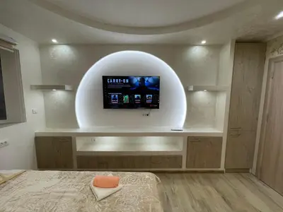 a bedroom with a flat screen tv on a wall at Apartman 911 in Soko Banja