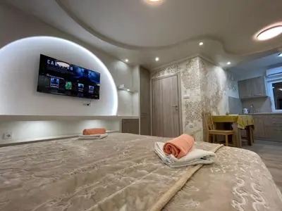 a bedroom with a large bed with a flat screen tv on the wall at Apartman 911 in Soko Banja