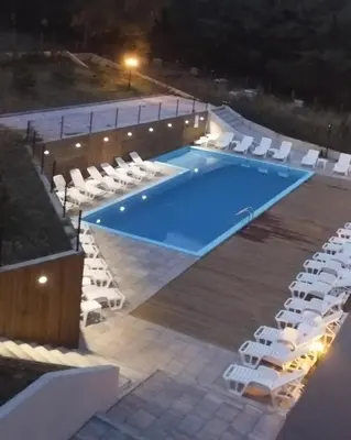 a swimming pool with white chairs and a swimming pool at VB Crown in Vrnjačka Banja