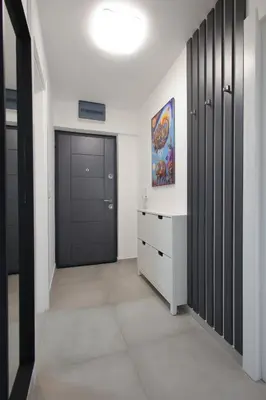 a hallway with black doors and a dresser in a room at Apartman SNEG in Vrnjačka Banja
