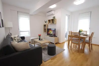 a living room with a couch and a dining room at Apartman SNEG in Vrnjačka Banja