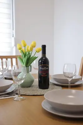 a bottle of wine sitting on a table with glasses at Apartman SNEG in Vrnjačka Banja
