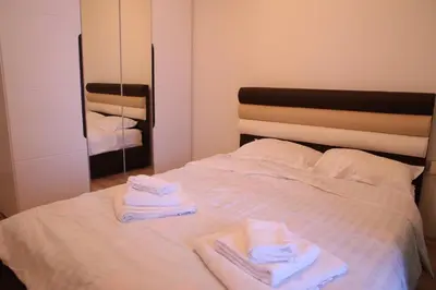a bedroom with a bed with towels and a mirror at Stan na dan 2 in Paraćin