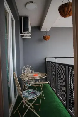 a table and chairs on a balcony with green carpet at Stan na dan 2 in Paraćin