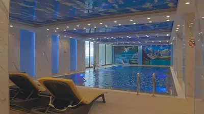 a large swimming pool in a room with blue ceilings at President Kop A104 in Kopaonik