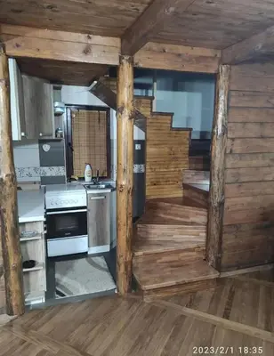 a kitchen with wooden walls and a stove top oven at Apartmani Maljković in Knjazevac.