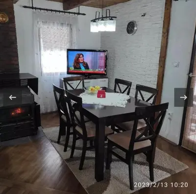 a dining room with a table with chairs and a tv at Apartmani Maljković in Knjazevac.