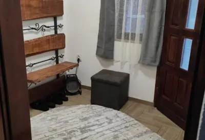 a bedroom with a bed and a stool and a window at Studio Maljković in Knjazevac.