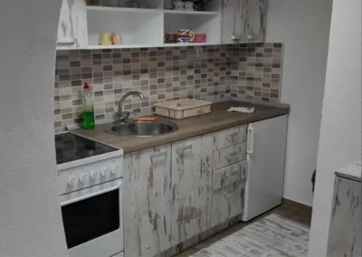 a dirty kitchen with a sink and a stove at Studio Maljković in Knjazevac.