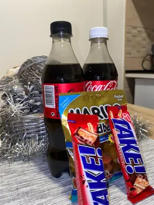 two bottles of coke and two bags of snacks at Apartman Filip in Kruševac