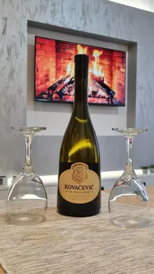 a bottle of wine sitting on a table with two glasses at Apartman Filip in Kruševac