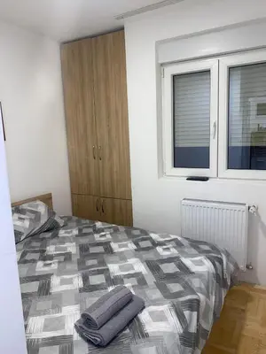 a bedroom with a bed and a window at Apartman Filip in Kruševac
