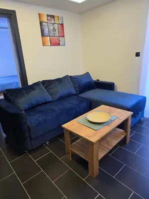 a blue couch in a living room with a table at Tara Apartments Kopaonik in Kopaonik