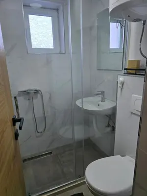 a bathroom with a shower and a toilet and a sink at Tara Apartments Kopaonik in Kopaonik