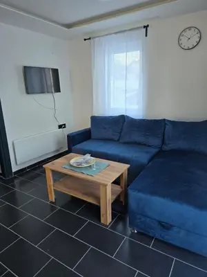 a living room with a blue couch and a coffee table at Tara Apartments Kopaonik in Kopaonik