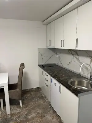 a kitchen with a sink and a table and a chair at Studio Ivana 3 in Soko Banja