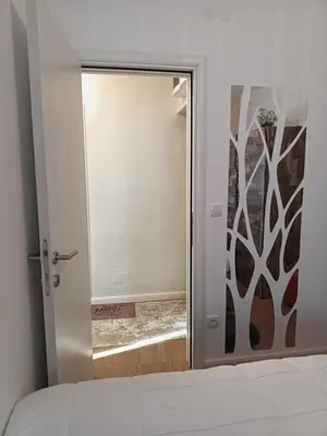 a bedroom with a door leading to a mirror at Gold Apartman in Kruševac