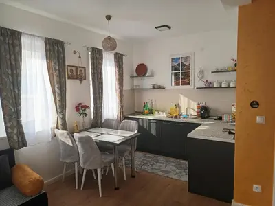 a kitchen with a table and chairs in a room at Gold Apartman in Kruševac