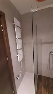 a bathroom with a glass shower stall with a door at Apartman Milovan in Kopaonik