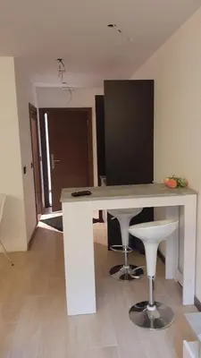 a white desk with two stools in a room at Apartman Milovan in Kopaonik