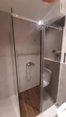 a glass shower stall with a toilet in a bathroom at Apartman Milovan in Kopaonik