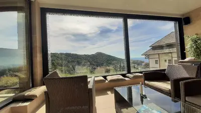 a living room with a large window with a couch at Apartman Milovan in Kopaonik