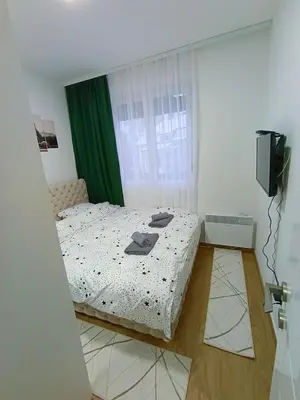 a bedroom with a bed and a window and a television at MSapartman in Vrnjačka Banja