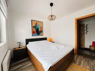 a bedroom with a large bed with white sheets at Ski2Door Apartment - Sunčani Breg, 50m from Ski Slope in Kopaonik