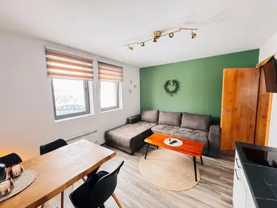 a living room with a couch and a table at Ski2Door Apartment - Sunčani Breg, 50m from Ski Slope in Kopaonik