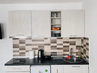a kitchen with white cabinets and a sink at Ski2Door Apartment - Sunčani Breg, 50m from Ski Slope in Kopaonik