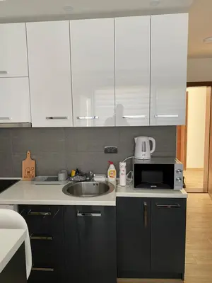 a kitchen with white cabinets and a sink and a microwave at Residence Hill , apartman Stefan A023 in Kopaonik