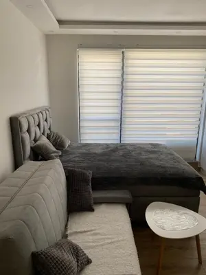 a bedroom with a large bed and a couch at Residence Hill , apartman Stefan A023 in Kopaonik