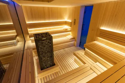 an empty sauna with a black rack in the middle at Apart-Hotel Ariš Kopaonik in Kopaonik