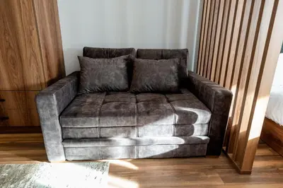 a leather couch with two pillows in a living room at Apart-Hotel Ariš Kopaonik in Kopaonik