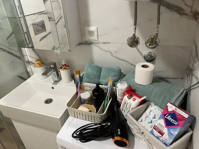 a bathroom with a sink and a counter with toiletries at Apartman S in Vrnjci
