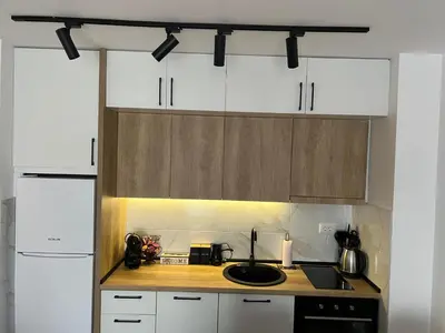 a kitchen with white cabinets and a sink at Apartman S in Vrnjci