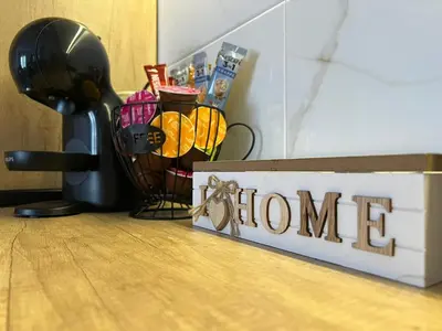a wooden sign with the word home next to a blender at Apartman S in Vrnjci