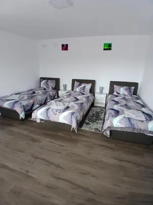 three beds are lined up in a room at Apartmani SARA Vranje in Vranje